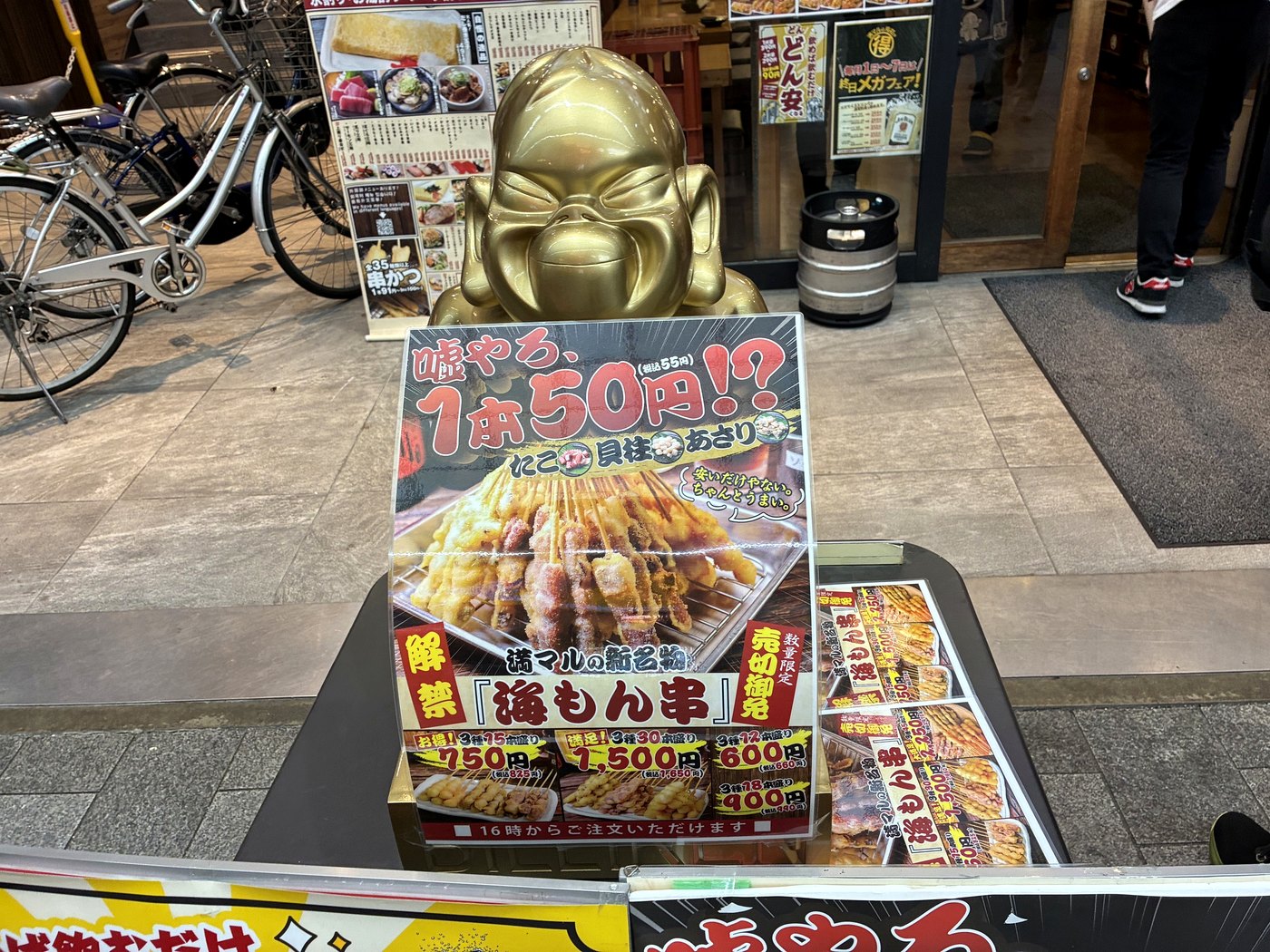 大阪 満マルの店頭にあるビリケンさんと串カツ50円の案内